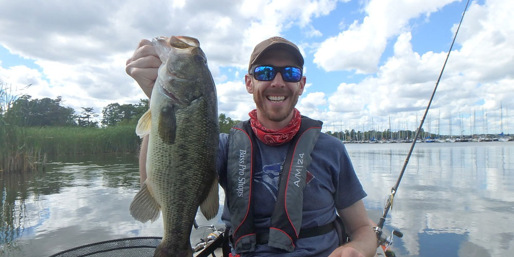 Matthew Randall holding a largemouth bass at Frenchman's Bay.