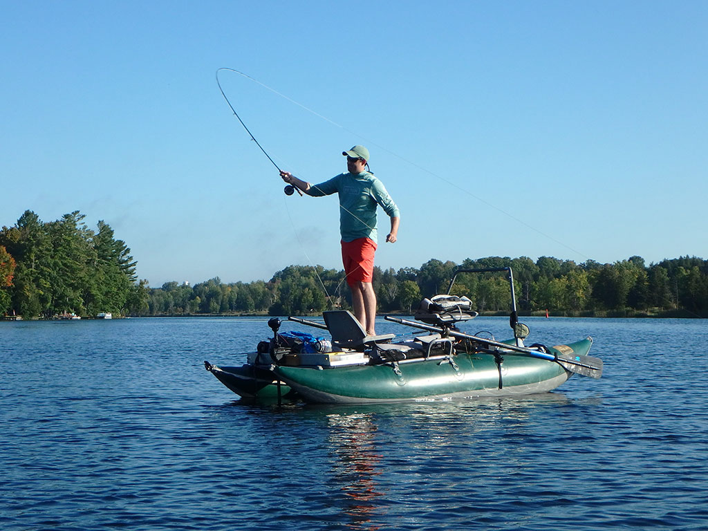 Matthew Randall's friend Josh fly fishing for musky in his pontoon boat.