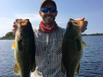 Matthew Randall holding two largemouth bass on Georgian Bay.