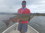 Matthew Randall's coworker holding a large salmon